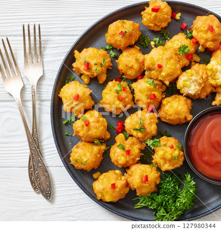 corn nuggets on a plate with tomato sauce 127980344
