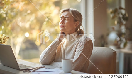 Woman experiencing neck pain at home. 127980523