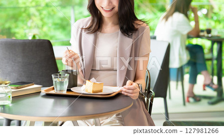 Woman eating cake at a cafe Woman eating cake at a cafe 127981266
