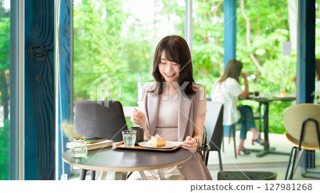 Woman eating cake at a cafe Woman eating cake at a cafe 127981268
