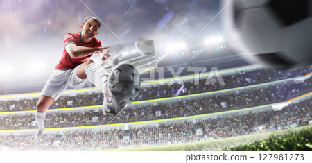 Soccer. Professional soccer player in action. Sport emotion. Soccer kick. Professional soccer player hits the ball for the winning goal. Championship 127981273
