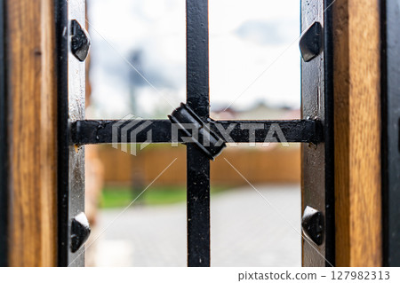 Selective focus, texture of a metal old lattice fence against the blue sky, fence lattice, lattice background, cell. High quality photo Selective focus, texture of a metal old lattice fence against the blue sky, fence lattice, lattice background, cell. High quality photo 127982313