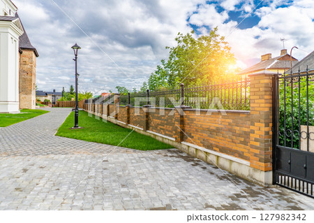 Green sunny courtyard of beautiful student buildings of the university on a summer day. 127982342