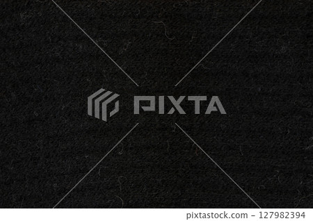 Texture of smooth black fabric captured in natural light during the day 127982394