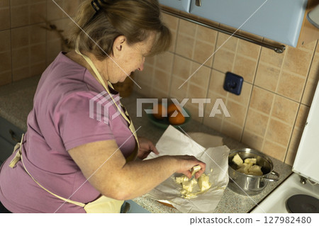 A senior woman prepares sweet butter to make ghee at home 127982480