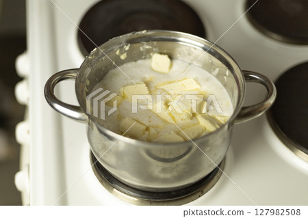 semi-melted butter in a saucepan on the stove semi-melted butter in a saucepan on the stove 127982508