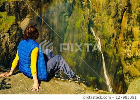 Tourist woman at Voringsfossen waterfall Norway Tourist woman at Voringsfossen waterfall Norway 127983381