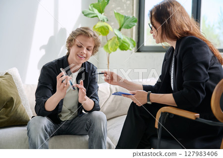 Teenage boy in mental therapy session, talking with behavioral psychologist Teenage boy in mental therapy session, talking with behavioral psychologist 127983406