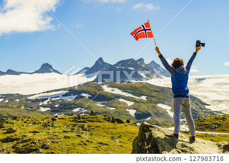Tourist with camera and flag in Norway mountains 127983718