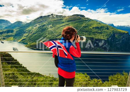 Tourist taking photo of fjord landscape, Norway Tourist taking photo of fjord landscape, Norway 127983729