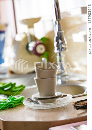 Dirty cups after coffee drinking, messy kitchen Dirty cups after coffee drinking, messy kitchen 127983948