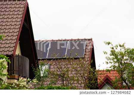 Installing a Solar Cell on a Roof. Solar panels on roof. Historic farm house with modern solar panels on roof and wall. High quality photo 127984082