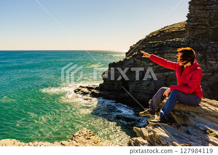 Tourist woman on sea cliffs in Spain Tourist woman on sea cliffs in Spain 127984119