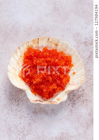 orange flying fish roe, Tobiko roe, in a seashell, top view, 127984194