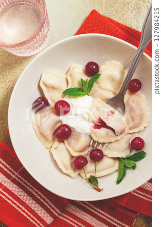 Traditional dumplings with cherries and yogurt, close-up, no people, 127984215