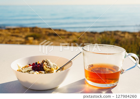 Healthy breakfast on ocean beach background Healthy breakfast on ocean beach background 127984260