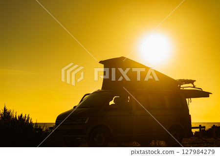 Camper van with tent on roof at sunset Camper van with tent on roof at sunset 127984279