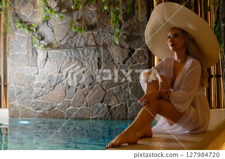 Relaxing woman in sauna enjoying a serene spa experience Relaxing woman in sauna enjoying a serene spa experience 127984720