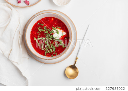 Traditional Ukrainian borscht with sour cream, garlic and rye bread on white table. Top view Traditional Ukrainian borscht with sour cream, garlic and rye bread on white table. Top view 127985022