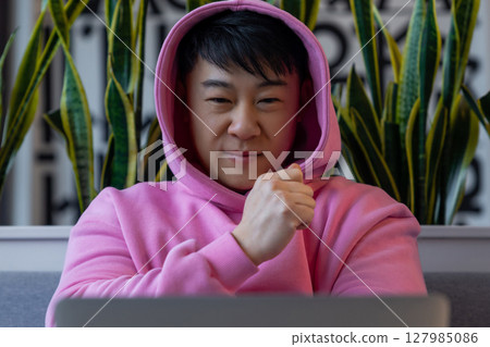 Asian young man at the laptop looking serious and concentrated 127985086