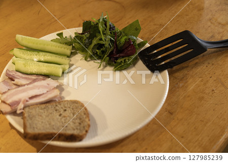 preparing breakfast on a plate meat, greens, cucumbers preparing breakfast on a plate meat, greens, cucumbers 127985239