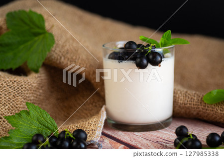 Fresh healthy breakfast of yogurt and blackcurrant berries on a wooden 127985338