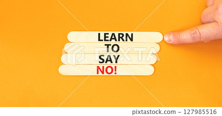Learn to say no symbol. Concept words phrase Learn to say no on beautiful wooden stick. Businessman's hand. Beautiful orange background. Business psychological Learn to say no concept. Copy space. Learn to say no symbol. Concept words phrase Learn to say no on beautiful wooden stick. Businessman's hand. Beautiful orange background. Business psychological Learn to say no concept. Copy space. 127985516