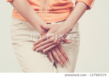 woman with hands holding her crotch woman with hands holding her crotch 127985574