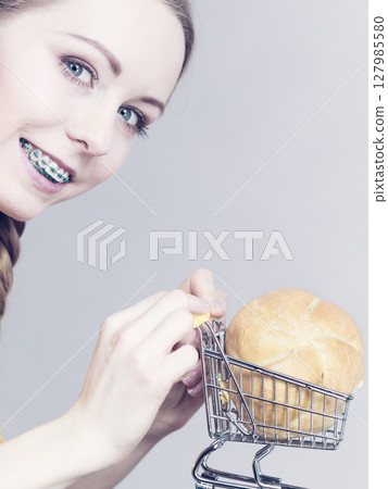 Woman holding shopping cart with bread 127985580