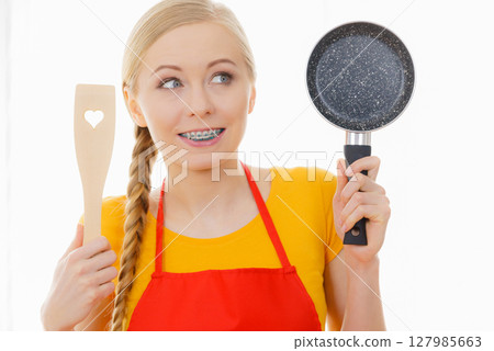Woman holding cooking pan and spatula Woman holding cooking pan and spatula 127985663