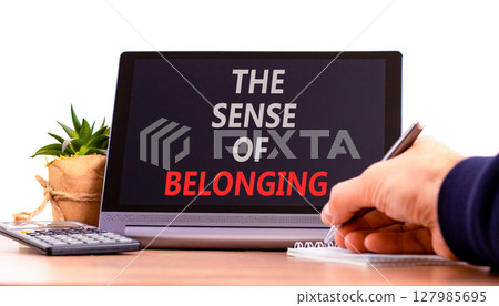 The sense of belonging symbol. Concept words The sense of belonging on beautiful black tablet. Beautiful white background. Businessman hand. Business and the sense of belonging concept. Copy space. 127985695