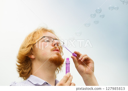 Man blowing soap bubbles, having fun 127985813