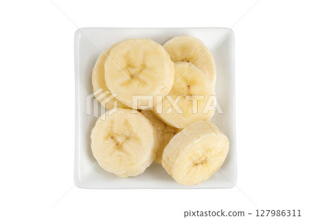 peeled banana pieces in ceramic bowl isolated on white background. Top view. Flat lay. 127986311