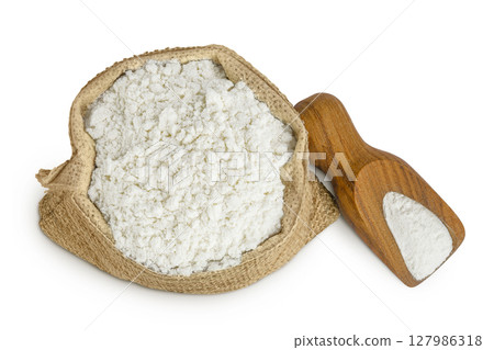 White flour in a paper bag and wooden scoop isolated on white background. Top view. Flat lay. White flour in a paper bag and wooden scoop isolated on white background. Top view. Flat lay. 127986318