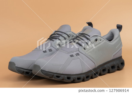 Sleek gray athletic shoes designed for comfort and performance in outdoor activities Sleek gray athletic shoes designed for comfort and performance in outdoor activities 127986914