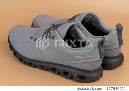 Stylish gray sneakers designed for comfort and performance during various activities Stylish gray sneakers designed for comfort and performance during various activities 127986921