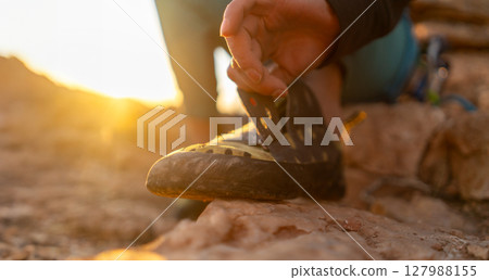 girl puts on special climbing shoes on her legs before climbing o 127988155