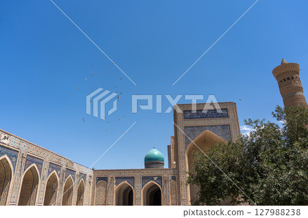 The magnificent mosque of Bukhara stands out against the wide blue sky 127988238