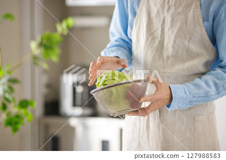Hands of a young man cutting vegetables Hands of a young man cutting vegetables 127988583