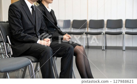 Men and women sitting quietly at a funeral Men and women sitting quietly at a funeral 127988621