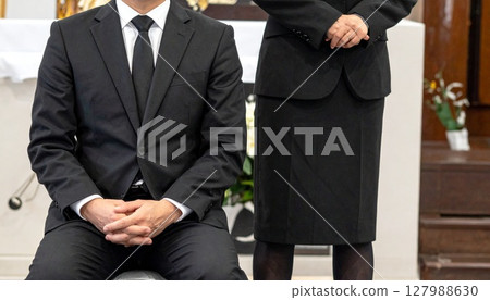 Men and women sitting quietly at a funeral Men and women sitting quietly at a funeral 127988630