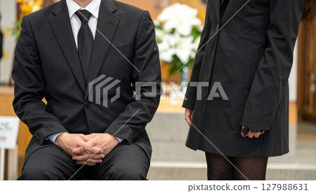 Men and women sitting quietly at a funeral Men and women sitting quietly at a funeral 127988631