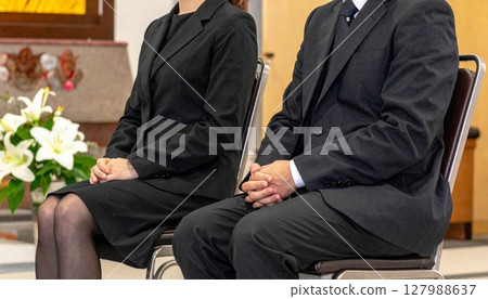 Men and women sitting quietly at a funeral Men and women sitting quietly at a funeral 127988637