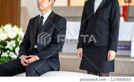 Men and women sitting quietly at a funeral Men and women sitting quietly at a funeral 127988638
