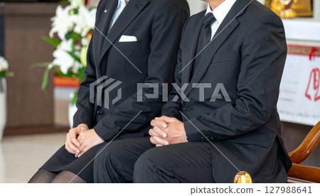 Men and women sitting quietly at a funeral Men and women sitting quietly at a funeral 127988641
