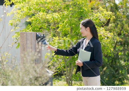 一位穿著西裝的女士參觀一棟房子 一位穿著西裝的女士參觀一棟房子 127988939