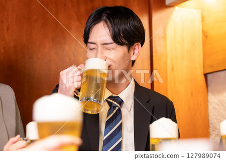 Drinking party: Men and women drinking at an izakaya Drinking party: Men and women drinking at an izakaya 127989074