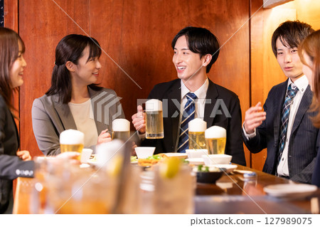 Drinking party: Men and women drinking at an izakaya Drinking party: Men and women drinking at an izakaya 127989075