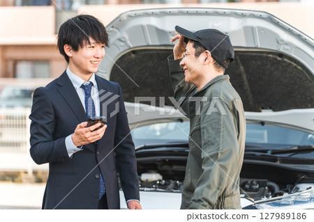 一名男工人和一名男司機趕到道路服務處。 127989186