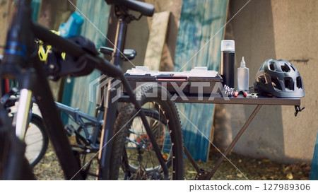 Glimpse of expert toolkit neatly arranged on table alongside an assortment of other tools and a helmet all set for outdoor bike maintenance. Specialized equipment ready for bicycle repair. 127989306